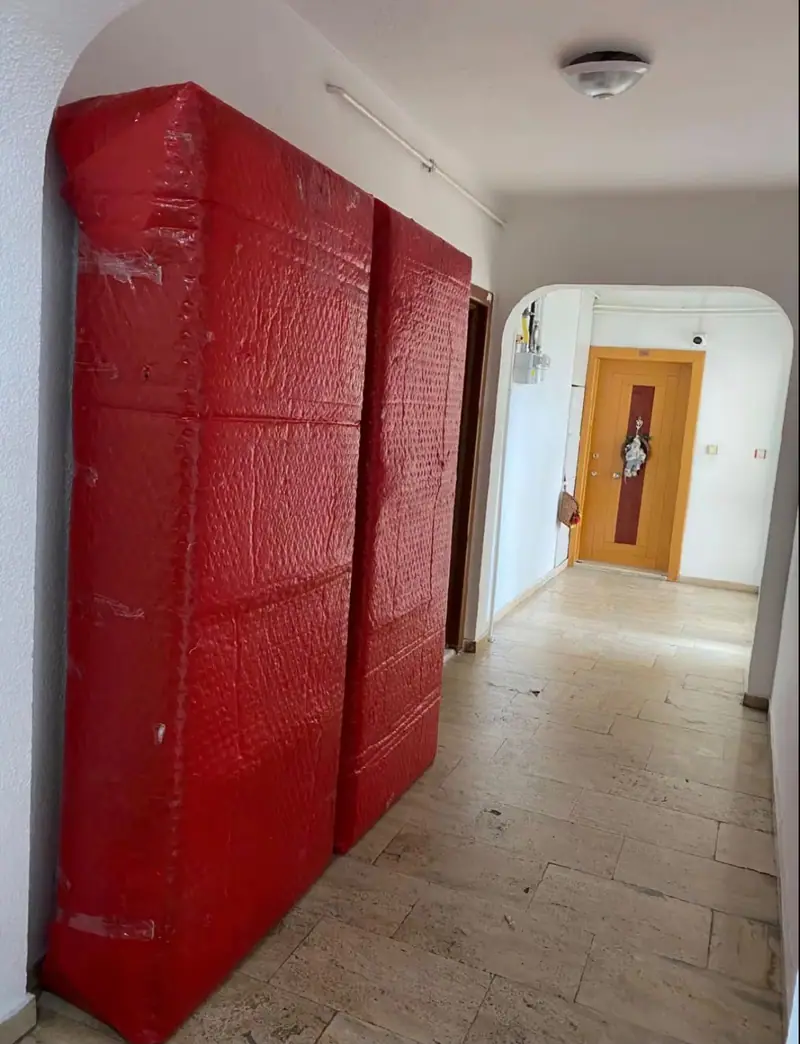 Koridorda taşınmaya hazır, kırmızı ambalajlı gardırop modülleri